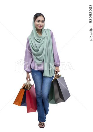 Asian Muslim woman in a headscarf holding shopping bags 98092088