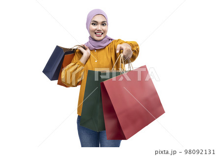 Asian Muslim woman in a headscarf holding shopping bags 98092131