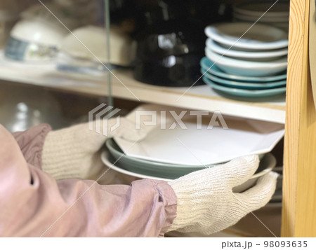 食器棚からお皿を取り出す軍手をした手元 食器棚からお皿を取り出す軍手をした手元 98093635