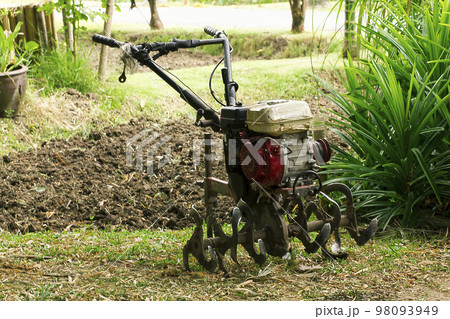 Rotary tiller helps to prepare the soil for modern farmers. 98093949