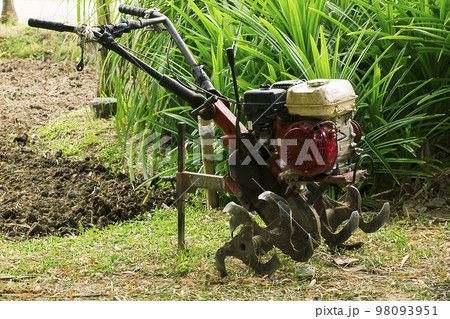 Rotary tiller helps to prepare the soil for modern farmers. 98093951