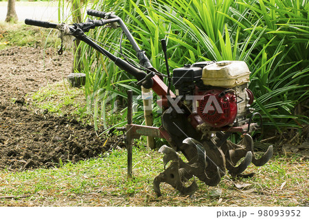 Rotary tiller helps to prepare the soil for modern farmers. 98093952