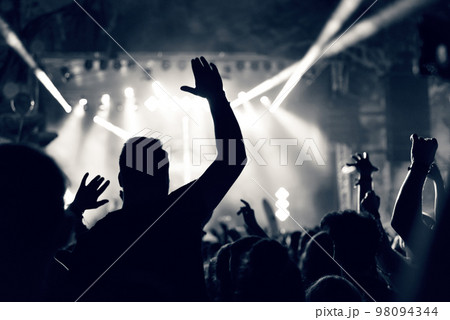 Crowd at a music concert, audience raising hands up, toned 98094344