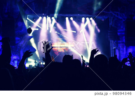 Crowd rocking during a concert with raised arms. 98094346