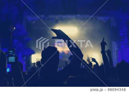 Crowd with arms outstretched at concert 98094348
