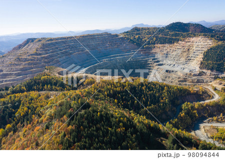 Flying above an open pit mine, copper excavation in Rosia Poieni, Romania. Aerial view 98094844