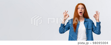 Amused, excited and thrilled good-looking redhead female in denim shirt, open mouth, drop jaw speechless staring with popped eyes camera, showing okay gesture in approval, white background Amused, excited and thrilled good-looking redhead female in denim shirt, open mouth, drop jaw speechless staring with popped eyes camera, showing okay gesture in approval, white background 98095004