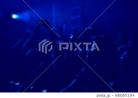 Crowd rocking during a concert with raised arms. 98095594