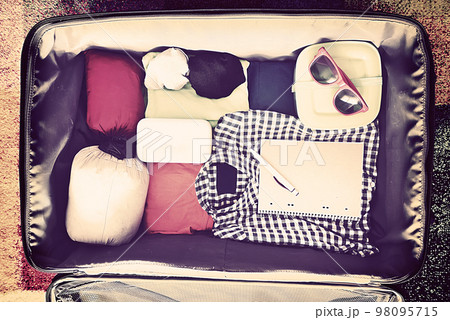 Travel accessories in a suitcase. Vintage toned Travel accessories in a suitcase. Vintage toned 98095715