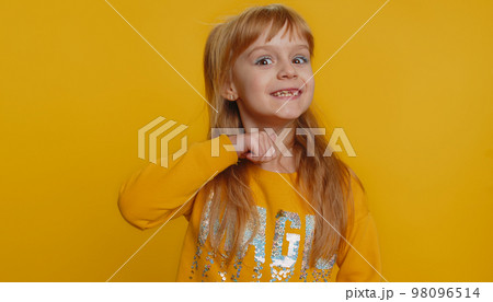 Angry young preteen child girl kid mimicking knife with finger showing gesture of cutting throat 98096514