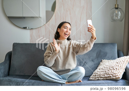 Beautiful chatty girl video chats, making video on smartphone, taking selfie, smiling at mobile phone camera Beautiful chatty girl video chats, making video on smartphone, taking selfie, smiling at mobile phone camera 98096596