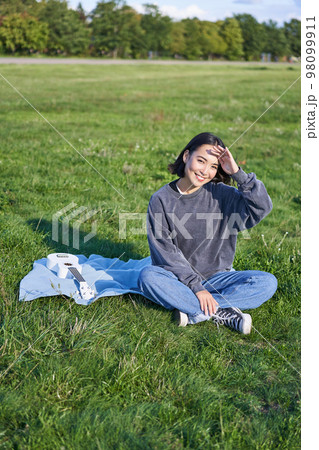 Beautiful asian girl, musician sitting in park and playing ukulele, smiling happy at camera. Lifestyle and young people concept Beautiful asian girl, musician sitting in park and playing ukulele, smiling happy at camera. Lifestyle and young people concept 98099911