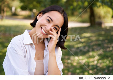 Beautiful young asian girl smiling, laughing and walking along park, enjoying summer sunny day Beautiful young asian girl smiling, laughing and walking along park, enjoying summer sunny day 98099912