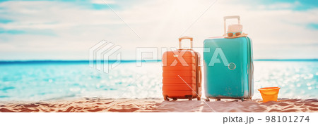 Panoramic view of the seacoast with suitcases on the sandbeach. 98101274