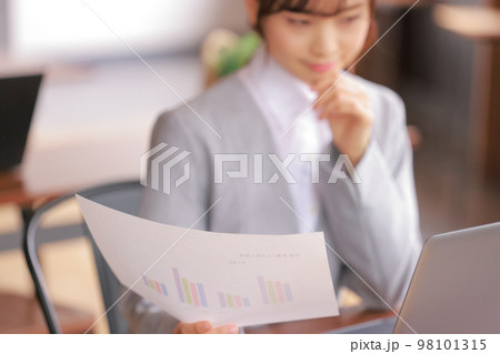 デスクワーク_グラフを手に持ち考える女性_1 デスクワーク_グラフを手に持ち考える女性_1 98101315