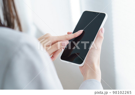スマートフォンを操作するビジネスウーマン スマートフォンを操作するビジネスウーマン 98102265