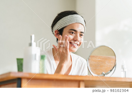 顔に保湿クリームを塗る若い男性 顔に保湿クリームを塗る若い男性 98102304