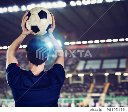 Close up of a football action scene with soccer player throws a soccerball Close up of a football action scene with soccer player throws a soccerball 98105156