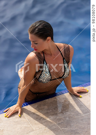 Woman in swimming pool on roof 98108079
