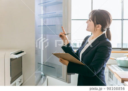 キッチンの電気・冷蔵庫をチェック・点検するビジネスウーマン 98108856