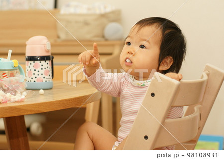 女の子の赤ちゃんが何かに注目し指をさしている│0～1歳児の女児・乳児 98108931
