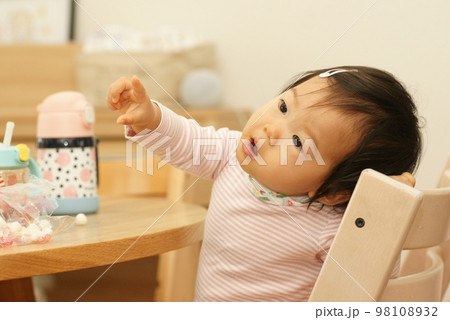 女の子の赤ちゃんが何かに興味をしめして指をさしている│0～1歳児の女児・乳児 98108932