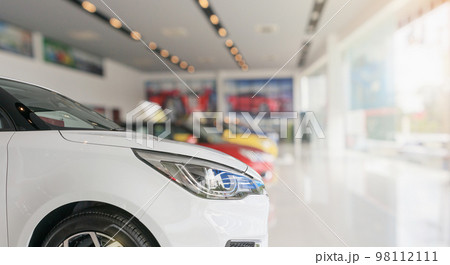 closeup front of new car in showroom background closeup front of new car in showroom background 98112111