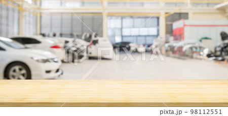 Empty wood table top with car service centre auto repair workshop blurred background 98112551