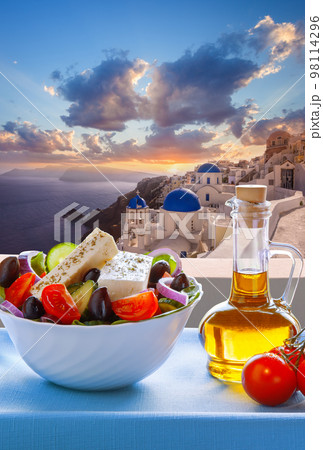 Greek food against famous churches in Oia village on Santorini island in Greece Greek food against famous churches in Oia village on Santorini island in Greece 98114296
