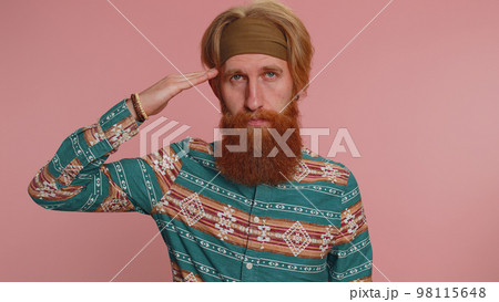 Subordinate hippie man giving salute listening to order as if soldier, following discipline, obeying 98115648