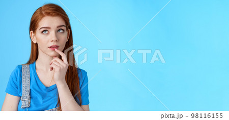 Close-up curious dreamy creative redhead female working project, student thinking essay, touch lip intrigued, look up thoughtful, pondering choice, make assumptions, stand blue background Close-up curious dreamy creative redhead female working project, student thinking essay, touch lip intrigued, look up thoughtful, pondering choice, make assumptions, stand blue background 98116155