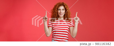 Excited good-looking cheeky redhead ginger girl curly natural hair pointing raised index fingers up smiling impressed thrilled advising store directing promo advertising awesome haircare product Excited good-looking cheeky redhead ginger girl curly natural hair pointing raised index fingers up smiling impressed thrilled advising store directing promo advertising awesome haircare product 98116382