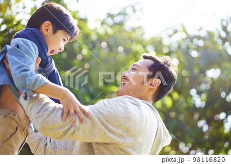 asian father having fun lifting son oudoors in park. asian father having fun lifting son oudoors in park. 98116820