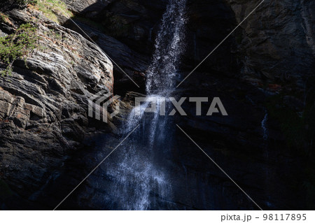 Lillaz waterfall break into millions of small splashes on harsh granite rock layers 98117895