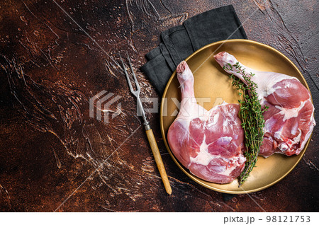 Raw duck legs. Poultry meat ready to cook. Dark background. Top view. Copy space Raw duck legs. Poultry meat ready to cook. Dark background. Top view. Copy space 98121753