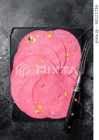 Slices of meat salami sausage with pistachios nuts on marble board. Black background. Top view Slices of meat salami sausage with pistachios nuts on marble board. Black background. Top view 98121786