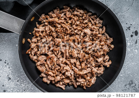 Pan fried minced meat to Italian pasta. Gray background. Top view Pan fried minced meat to Italian pasta. Gray background. Top view 98121787