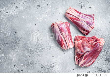 Uncooked Raw lamb shanks, mutton meat on kitchen table. Gray background. Top view. Copy space Uncooked Raw lamb shanks, mutton meat on kitchen table. Gray background. Top view. Copy space 98121800