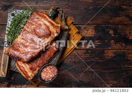 Meat restaurant kitchen. Smoked BBQ Pork Ribs on wooden cutting board. Wooden background. Top view. Copy space Meat restaurant kitchen. Smoked BBQ Pork Ribs on wooden cutting board. Wooden background. Top view. Copy space 98121802