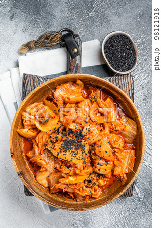 Kimchi cabbage in a wooden plate with chopsticks for eating , Korean cuisine. White background. Top view Kimchi cabbage in a wooden plate with chopsticks for eating , Korean cuisine. White background. Top view 98121918