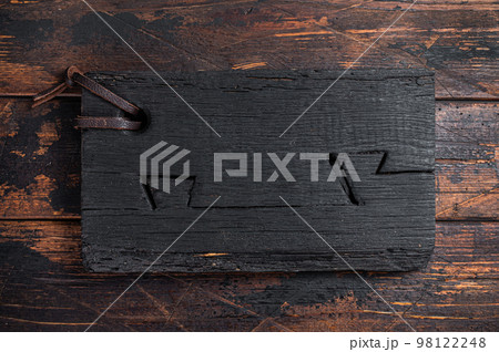 Black wooden Cutting board on kitchen table. Wooden background. Top view. Copy space Black wooden Cutting board on kitchen table. Wooden background. Top view. Copy space 98122248
