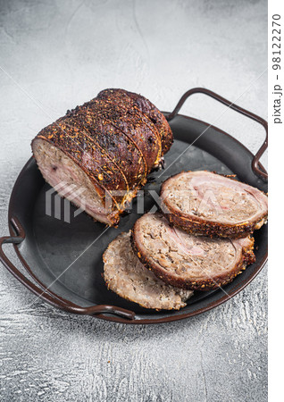 Sliced roast pork meat roulade on a steel tray. White background. Top view 98122270