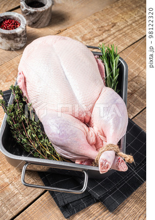 Cooking Christmas Raw whole duck with herbs and spices. Wooden background. Top view Cooking Christmas Raw whole duck with herbs and spices. Wooden background. Top view 98122320
