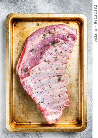 Marinated lamb mutton ribs with herbs and thyme in baking dish. White background. Top view 98122382