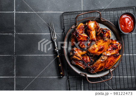 BBQ chicken wings in dip Barbecue sauce. Black background. Top view. Copy space 98122473