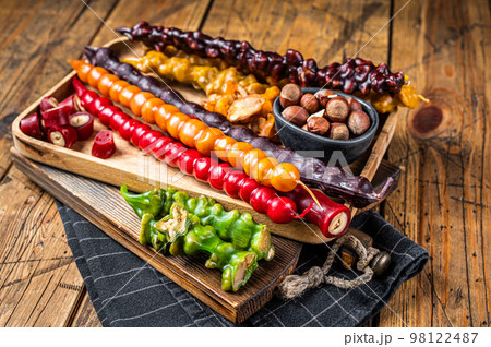 Colored Churchkhela Georgian sweets with Walnuts and hazelnuts. Wooden background. Top view Colored Churchkhela Georgian sweets with Walnuts and hazelnuts. Wooden background. Top view 98122487