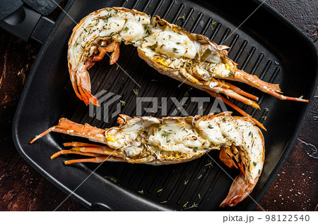 Delicious grilled and sliced Spiny lobster or sea crayfish. Dark background. Top view 98122540