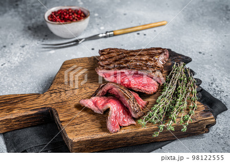 BBQ Grilled Wild Venison steak on wooden board. Gray background. Top view BBQ Grilled Wild Venison steak on wooden board. Gray background. Top view 98122555