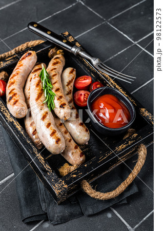 Grilled Bratwurst meat sausages with herbs and spices. Black background. Top view 98122573