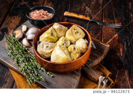 Appetizer Artichoke hearts pickled in olive oil with herbs and spices Wooden background. Top view Appetizer Artichoke hearts pickled in olive oil with herbs and spices Wooden background. Top view 98122673